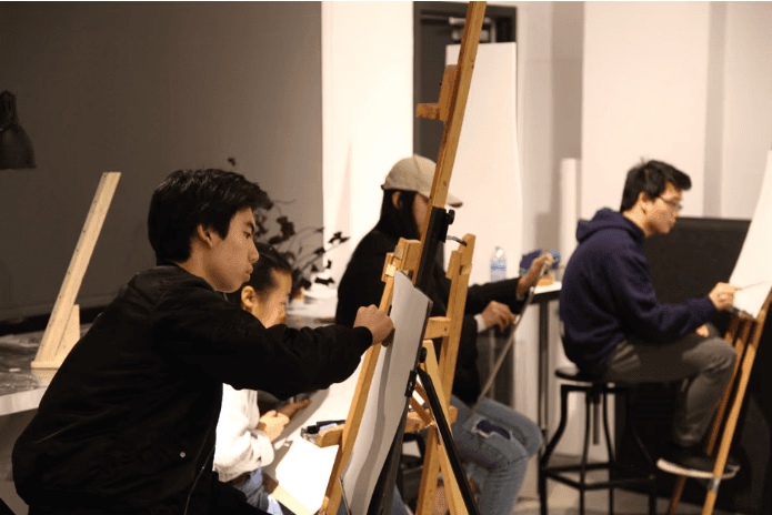 Students painting at easels during an evening Foundation Studio session