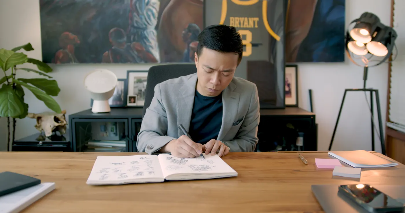 Studio founder sketching in an open notebook at his desk
