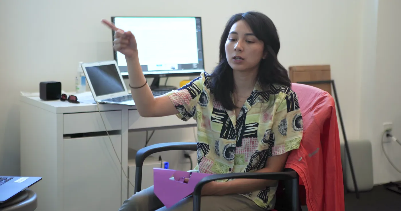 Mentor pointing at a monitor while giving a student feedback on their work