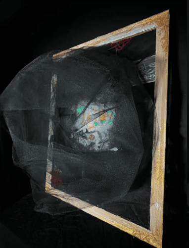 Mixed-media student artwork of black mesh fabric draped over a gilded frame against a dark background
