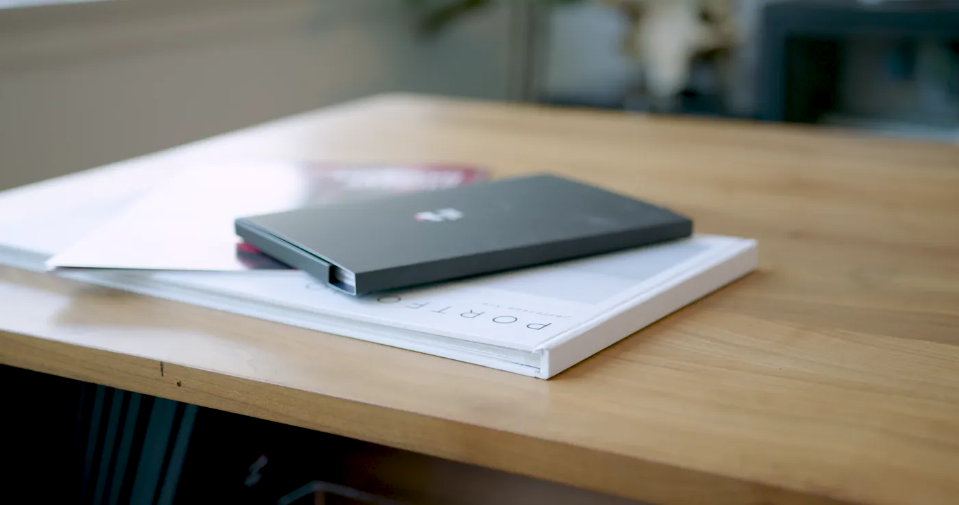 Printed portfolio book and laptop resting on the studio desk