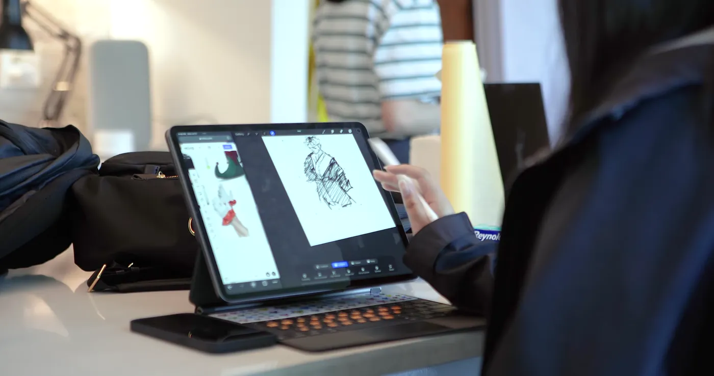 Student refining a digital character illustration on an iPad