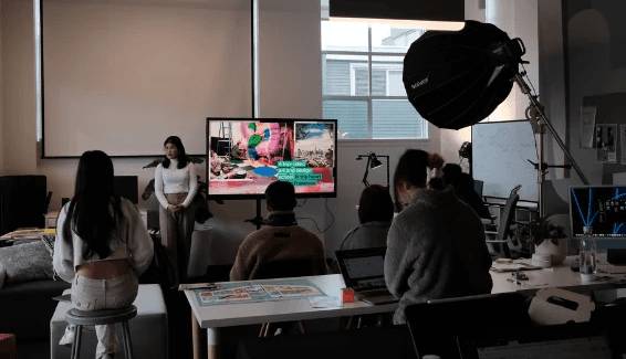 Student presenting work on a screen to a group during a studio critique session