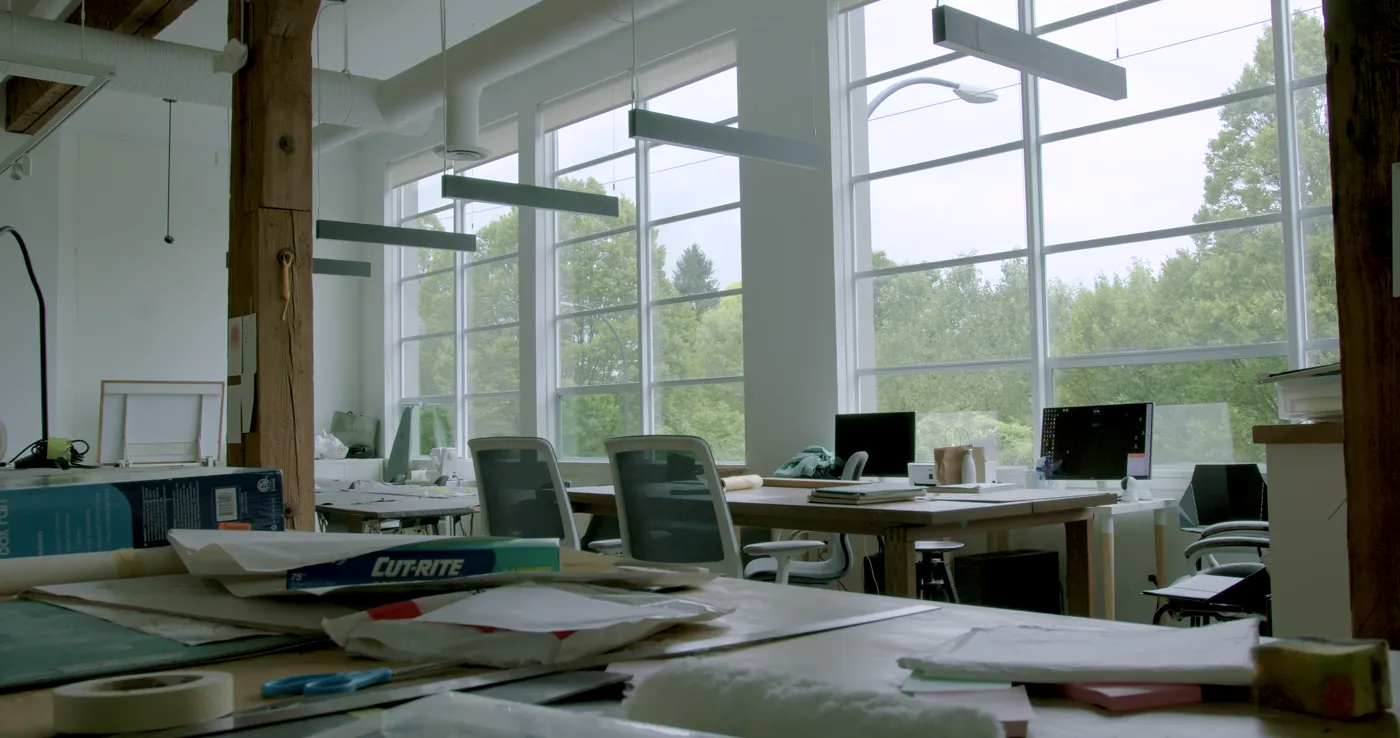 Worktables and drafting supplies in the daylit studio loft