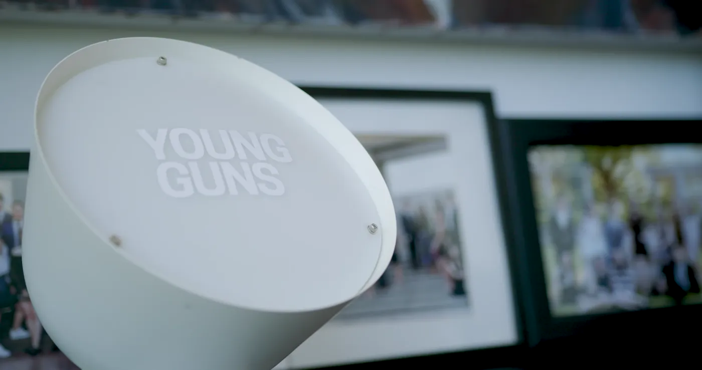 Young Guns sign resting on a shelf of framed studio photographs